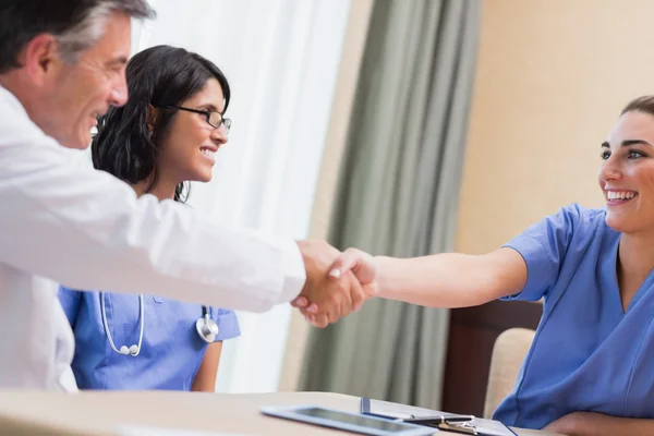 Infermiera e medico stringendo la mano — Foto Stock