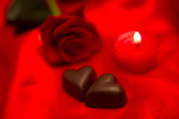 Red rose candle and chocolate hearts — Stock Photo, Image