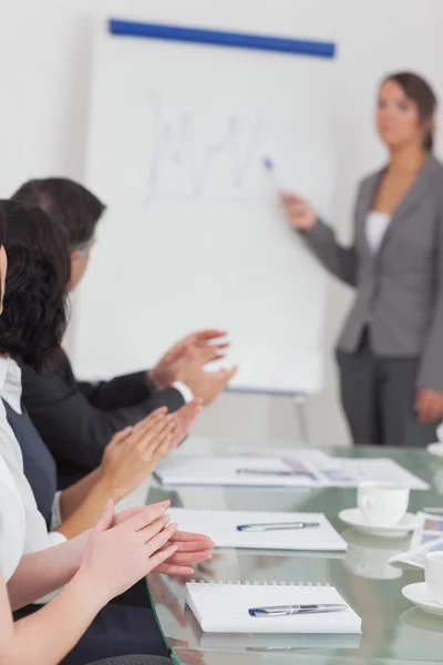 Businesswoman spiegando ei suoi colleghi applausi — Foto Stock