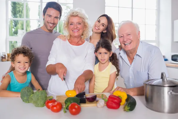 Familia multigeneracional que corta verduras juntas — Foto de Stock