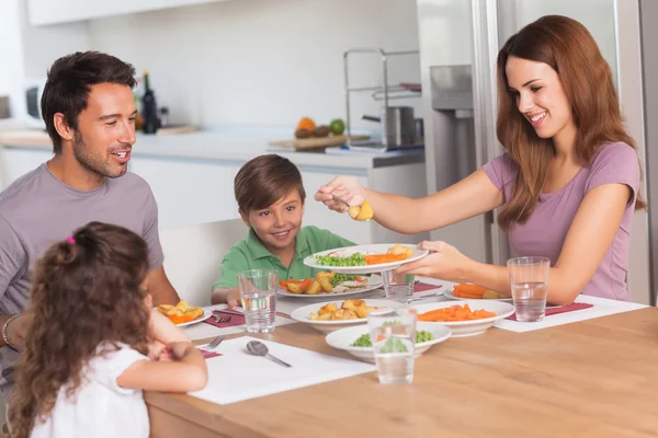 Mor portion grönsaker till dotter på middag — Stockfoto