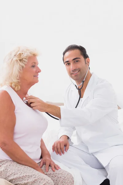 Cheerful doctor examining an old woman — Stock Photo, Image