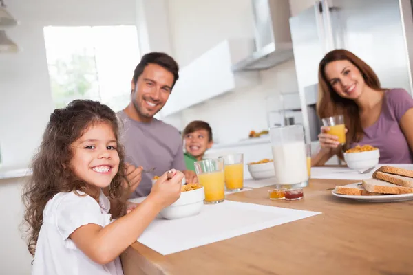 Familie lächelt beim Frühstück in die Kamera Stockfoto