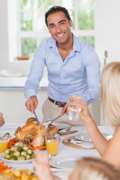 Smiling man carving the turkey Stock Picture