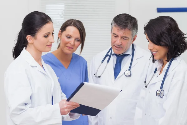 Nurse and doctors looking at clipboard Royalty Free Stock Images