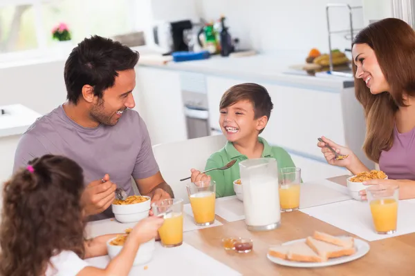 Family laughing around breakfast — Stock Photo, Image