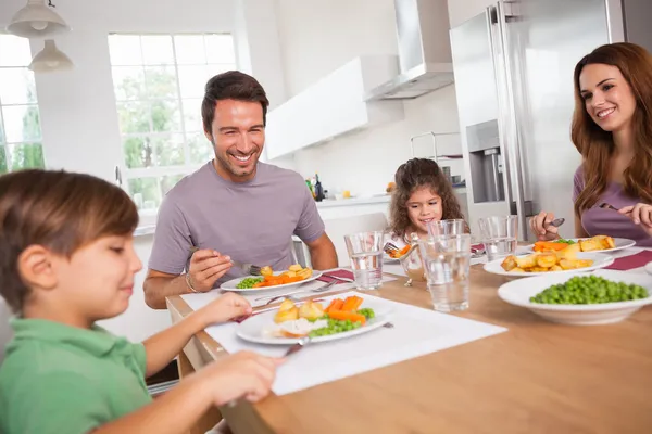 Familie lächelt um ein gutes Essen Stockfoto