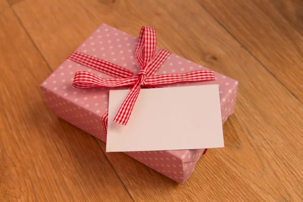 Pink wrapped present with blank card — Stock Photo, Image