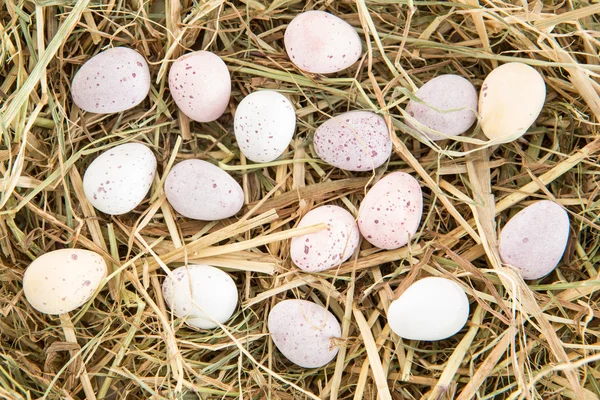 Petits œufs de Pâques bonbons sur paille — Photo