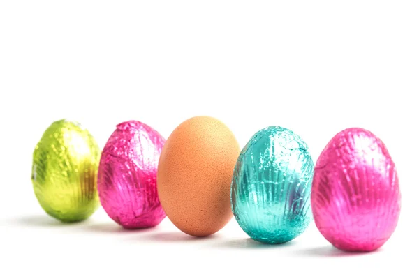 Fyra påskägg i rad med en riktig ägg — Stockfoto