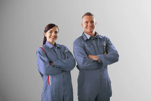Two mechanics standing on grey background — Stock Photo, Image