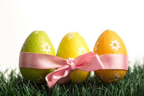Three easter eggs wrapped in pink ribbon — Stock Photo, Image