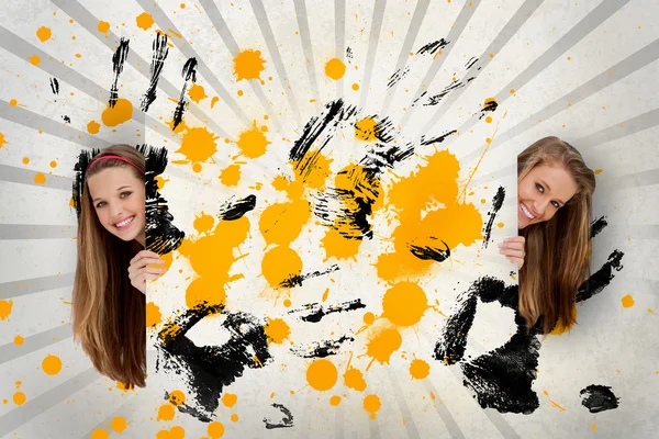 Due belle ragazze in possesso di arte astratta di inchiostro giallo e impronte di mani nere — Foto Stock