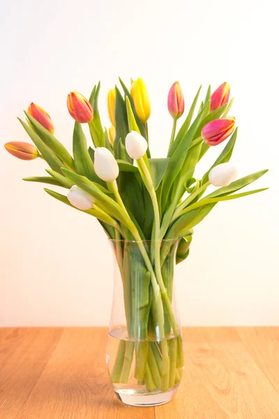 Vase of tulips on wooden table — Stock Photo, Image