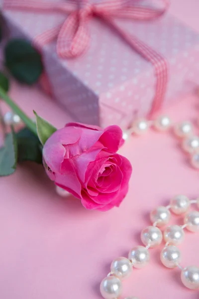 Roze roos met gift en parels — Stockfoto