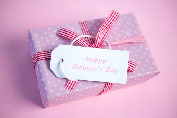 Pink gift wrapped box with happy mothers day tag — Stock Photo, Image