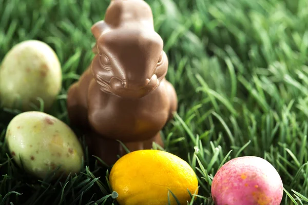 Conejito de chocolate con pequeños huevos de Pascua —  Fotos de Stock