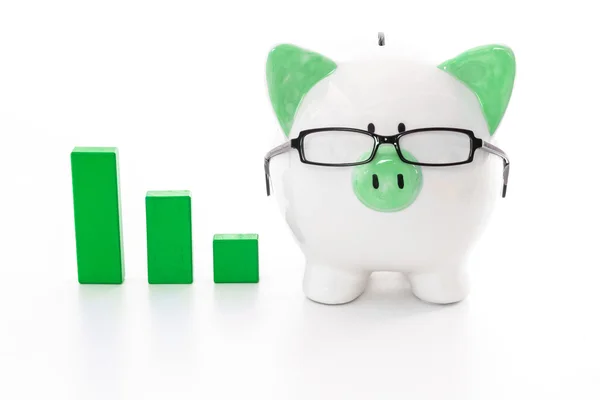 Piggy bank wearing glasses with green graph model — Stock Photo, Image