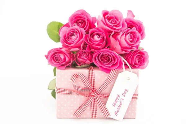 Bouquet di rose rosa accanto a un regalo rosa con una madre felice d — Foto Stock