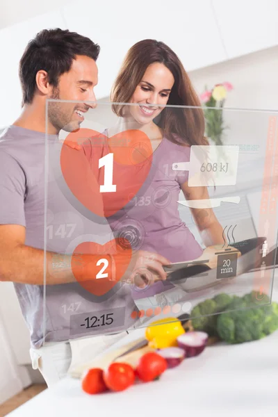 Smiling couple preparing dinner using futuristic interface — Stock Photo, Image