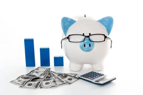 Piggy bank wearing glasses with dollars calculator and blue grap — Stock Photo, Image