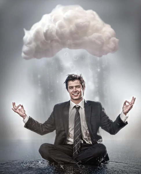 Businessman meditating under cloud — Stock Photo, Image