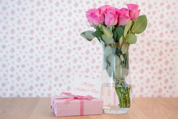 Bando de rosas rosa em vaso com presente rosa e cartão de dia de mães — Fotografia de Stock