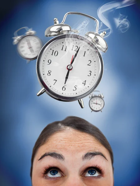 Woman looking up at ringing alarm clocks — Stock Photo, Image