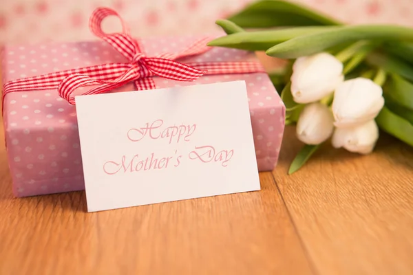 Pink wrapped present with bunch of white tulips and mothers day — Stock Photo, Image