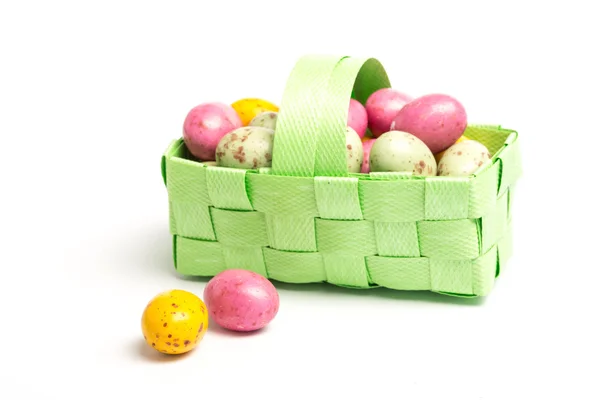Pequenos ovos coloridos de páscoa em uma cesta de vime verde — Fotografia de Stock