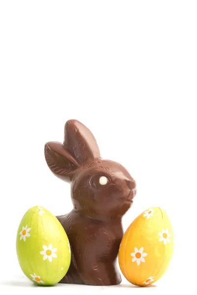 Шоколадный кролик с двумя пасхальными яйцами — стоковое фото