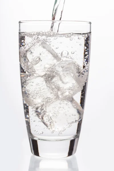 Hautnah auf sprudelndem Wasser, das ein Glas füllt — Stockfoto