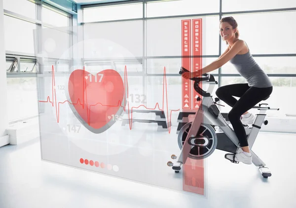 Chica joven haciendo bicicleta estática con interfaz futurista — Foto de Stock