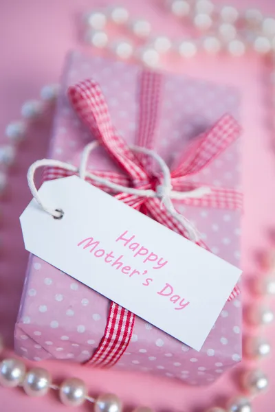 Caja envuelta de regalo rosa con saludo del día de las madres y perlas —  Fotos de Stock