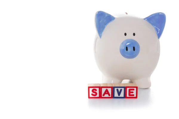 Blocks spelling save in front of piggy bank — Stock Photo, Image