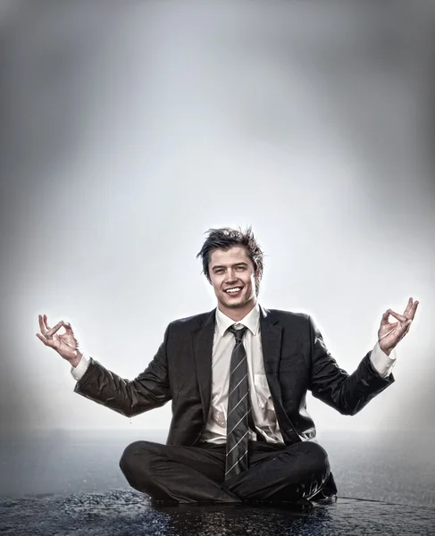 Businessman meditating and smiling — Stock Photo, Image