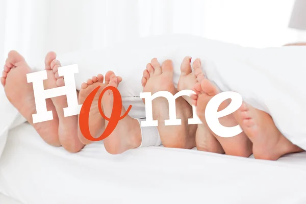 Les pieds de la famille dans le lit — Photo