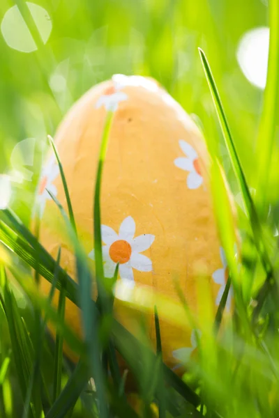 Huevo de Pascua envuelto en papel de aluminio enclavado en la hierba — Foto de Stock