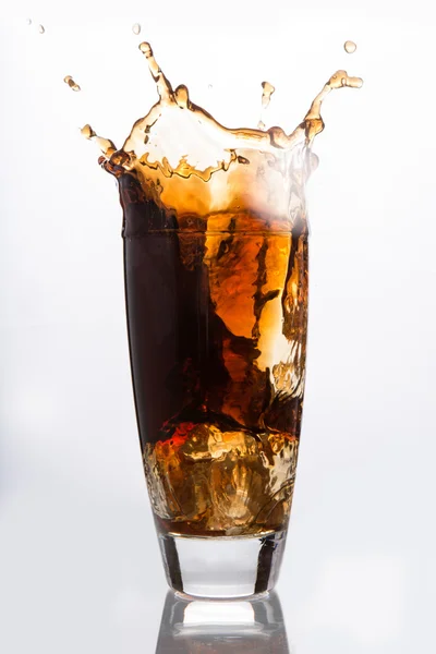 Eiswürfel fällt in ein Glas Soda — Stockfoto