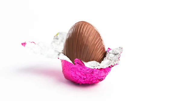 Uovo di Pasqua scartato in un foglio rosa — Foto Stock