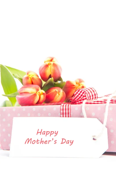 Bouquet of tulips on a gift with a happy mothers card — Stock Photo, Image
