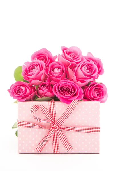 Bouquet of beautiful pink roses next to a pink gift on white bac — Stock Photo, Image