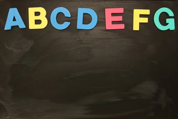 Αλφάβητο μαγνήτες κολλήσει στο blackboard μέχρι το γράμμα g — Φωτογραφία Αρχείου