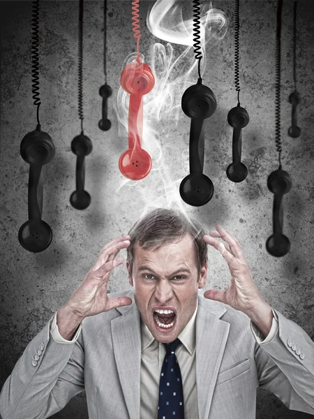 Stressed out businessman with phone receivers — Stock Photo, Image