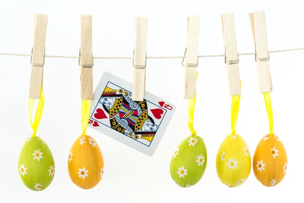 Easter eggs hanging from a line with queen of hearts — Stock Photo, Image