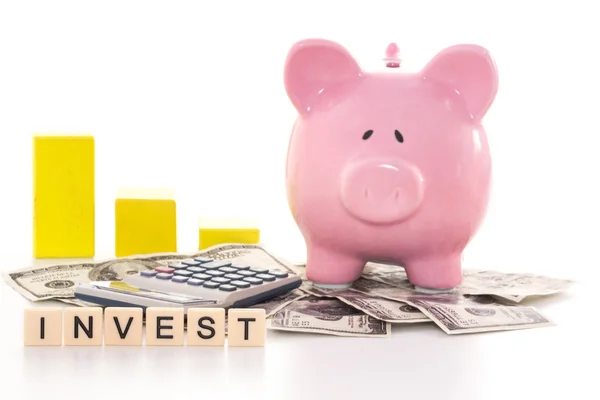 Piggy bank naast grafiek, rekenmachine en investeren gespeld in pl — Stockfoto