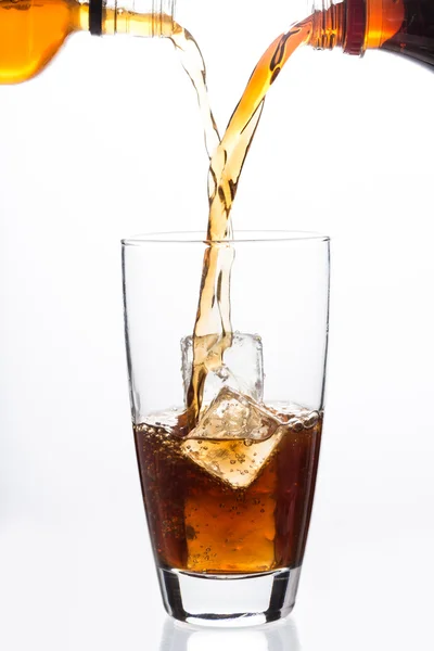 Dos botellas vertiendo en un vaso con cubo de hielo —  Fotos de Stock