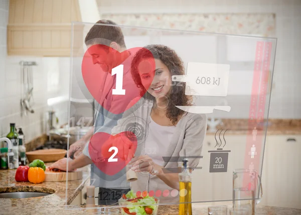 Happy couple making dinner using interface instructions — Stock Photo, Image