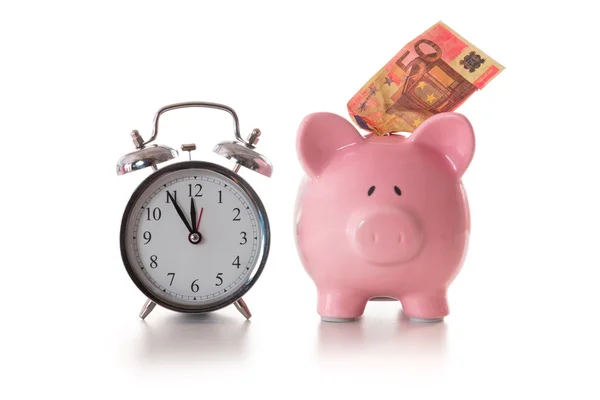 Alarm clock and piggy bank with fifty euro sticking out — Stock Photo, Image