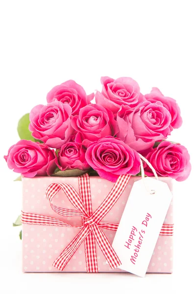 Bouquet of beautiful pink roses next to a pink gift with a happy Stock Image